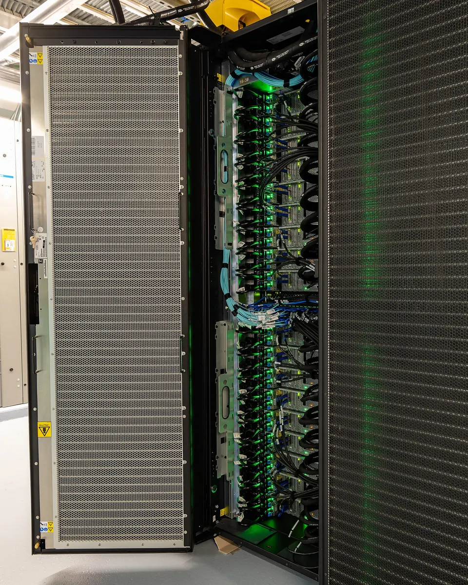 An open Summit supercomputer rack showing compute hardware and service connections